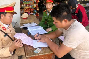 Công an lập biên bản vi phạm hành chính đối với người điều khiển ô-tô tải chở vật liệu, để đất rơi xuống đường.