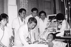 Giáo sư Vũ Văn Đính thăm khám bệnh nhân và giảng dạy cho các bác sĩ trẻ. (Ảnh tư liệu)