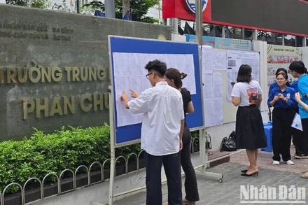 Sáng 6/6, nhiều thí sinh có mặt sớm tại các điểm thi. Trong ảnh: Thí sinh xem số báo danh, sơ đồ phòng thi tại điểm thi Trường THCS Phan Chu Trinh, Ba Đình, Hà Nội (Ảnh: TRUNG HIẾU)