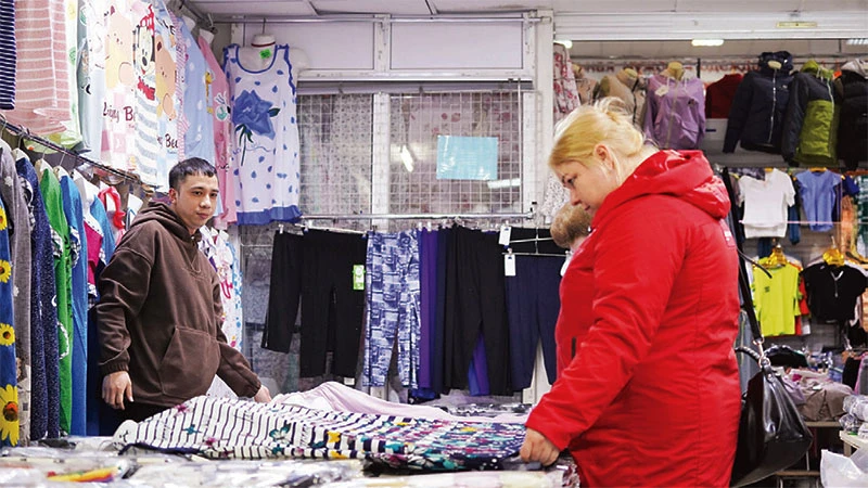 Quân bán hàng trong chợ.