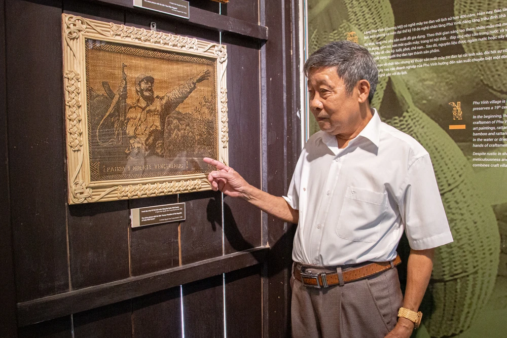 Nghệ nhân Nguyễn Văn Trung bên bức tranh Lãnh tụ Fidel Castro do ông đan sau ngày trở về Việt Nam.