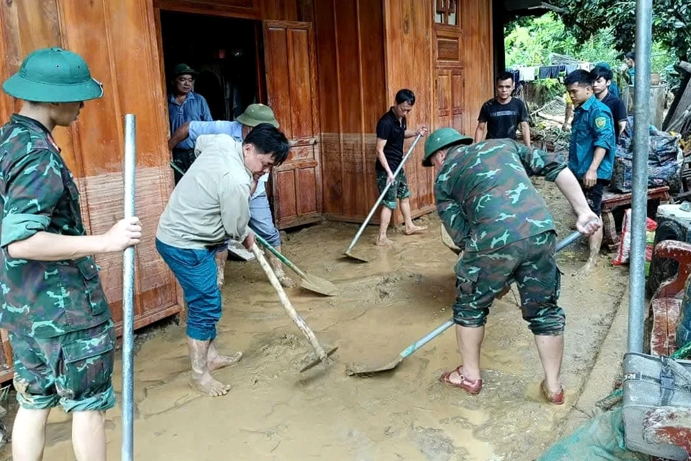 Lực lượng vũ trang và các tổ chức đoàn thể hỗ trợ các gia đình dọn dẹp bùn đất.
