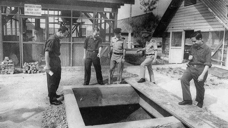 Thiếu tướng Hoàng Anh Tuấn, Trưởng đoàn đại biểu quân sự Chính phủ Cách mạng lâm thời Cộng hòa miền nam Việt Nam (thứ 2 từ trái sang), đang chỉ cái giếng mà phía địch vu cáo là hầm chiến đấu do ta đào trong Trại Davis (tháng 4/1975). (Ảnh: ĐINH QUỐC KỲ)