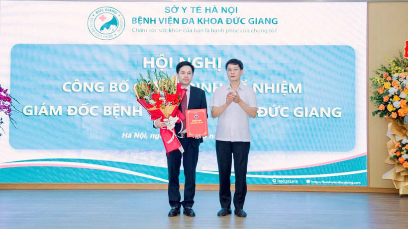 Phó Giám đốc Sở Y tế Hà Nội Vũ Cao Cương trao quyết định và tặng hoa chúc mừng tân Giám đốc Bệnh viện Đa khoa Đức Giang Đỗ Đình Tùng.