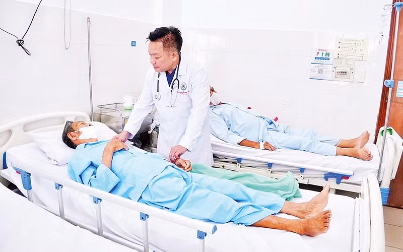 Tiến sĩ, bác sĩ Nguyễn Duy Tân thăm hỏi bệnh nhân Võ Hoành sau ca mổ.