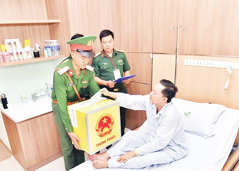 Bệnh nhân Bệnh viện Quân y 175 bỏ phiếu vào thùng phiếu di động. (Ảnh TÙNG LÂM)