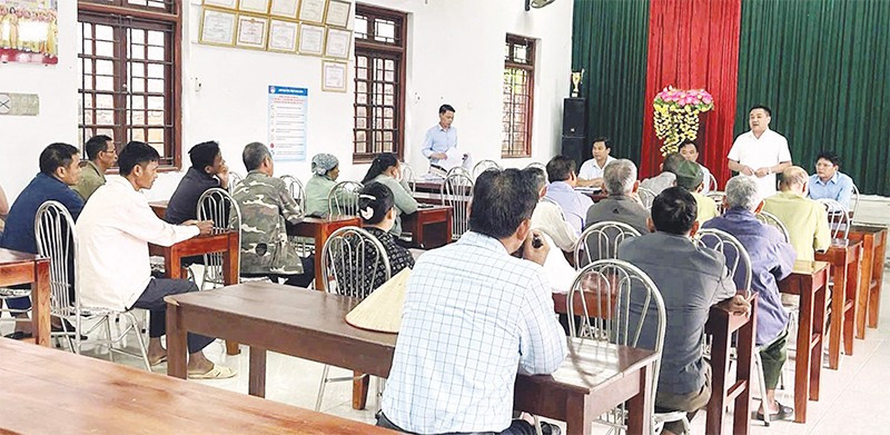 Cán bộ xã đối thoại với người dân có đất được thu hồi để triển khai dự án điện.