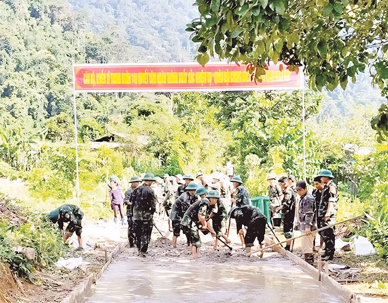 Cán bộ, chiến sĩ Trung đoàn 148 giúp người dân xã Yên Hoa làm đường bê-tông nông thôn.