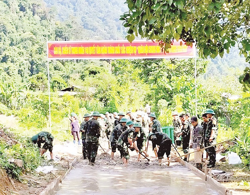 Cán bộ, chiến sĩ Trung đoàn 148 giúp người dân xã Yên Hoa làm đường bê-tông nông thôn.