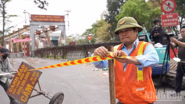 Biển báo và rào chắn được đặt tại các lối lên cầu Long Biên nhằm ngăn phương tiện lưu thông trong thời gian thi công. (Ảnh: HỒNG QUÂN)