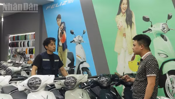 Nhân viên một cửa hàng xe máy điện tại Hà Nội giải đáp những nỗi lo của khách hàng khi chuyển qua sử dụng xe máy điện. (Ảnh: ANH DUY)