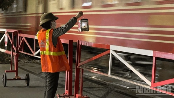 Nữ nhân viên đường sắt ngày ngày vẫn lặng lẽ bên thanh gác chắn bảo đảm an toàn cho mỗi chuyến tàu.