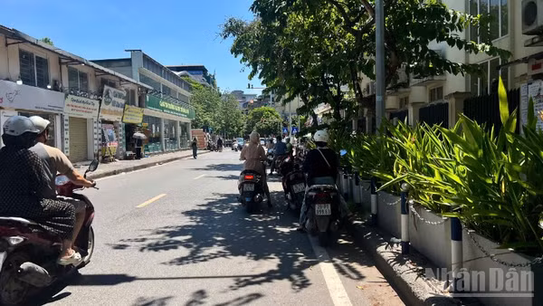 Người dân tận dụng những khoảng bóng râm ít ỏi để tránh nắng trong lúc chờ đèn đỏ. (Ảnh: YẾN PHƯƠNG)