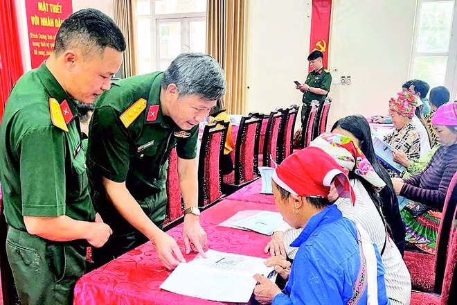 Cán bộ Đoàn Kinh tế-Quốc phòng 345 trao đổi, hướng dẫn người dân kỹ thuật chăn nuôi. (Ảnh QUANG PHẤN)