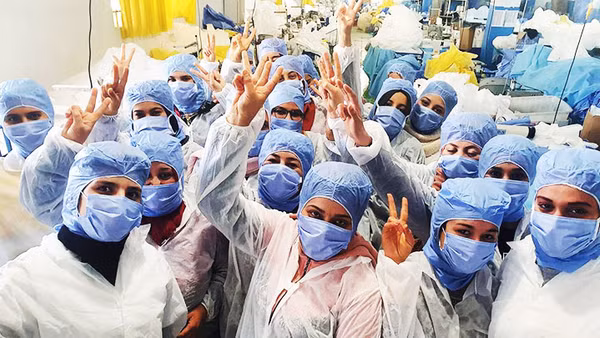 Dù luôn đối mặt nguy hiểm song các y, bác sĩ tuyến đầu chống dịch luôn lạc quan. Ảnh: AFP