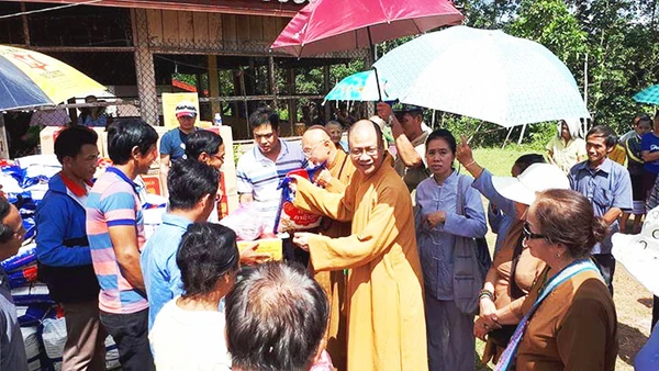 Thượng tọa Thích Minh Quang tặng quần áo, đồ dùng cho người dân Lào.