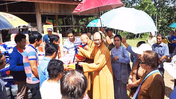 Thượng tọa Thích Minh Quang tặng quần áo, đồ dùng cho người dân Lào.