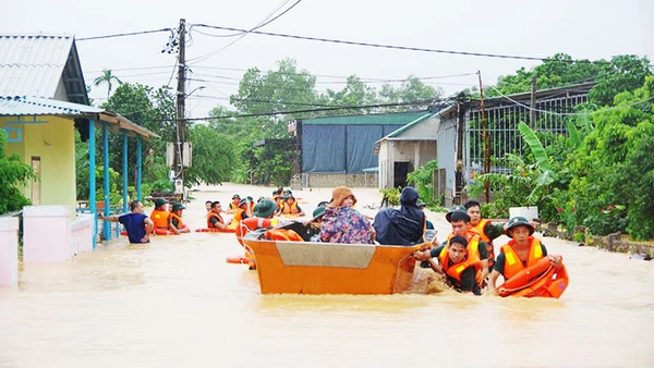 Cán bộ, chiến sĩ LLVT Quân khu 4 dầm mình trong mưa lũ để giúp đỡ nhân dân. Ảnh: TÂM QUANG