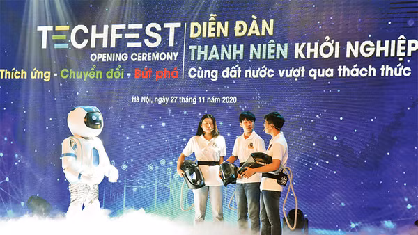 Màn đối thoại giữa rô-bốt và nhóm tác giả mũ cách ly di động Vihelm chống dịch Covid-19 tại lễ khai mạc diễn đàn Thanh niên khởi nghiệp năm 2020. Ảnh: ÐỨC ANH