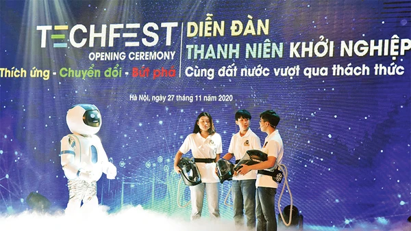 Màn đối thoại giữa rô-bốt và nhóm tác giả mũ cách ly di động Vihelm chống dịch Covid-19 tại lễ khai mạc diễn đàn Thanh niên khởi nghiệp năm 2020. Ảnh: ÐỨC ANH