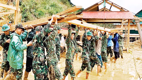 Cán bộ, chiến sĩ Đồn Biên phòng Ga Ry (Bộ Chỉ huy Bộ đội Biên phòng tỉnh Quảng Nam) giúp nhân dân huyện Tây Giang dựng lại nhà sau bão. Ảnh: PHAN TIẾN DŨNG