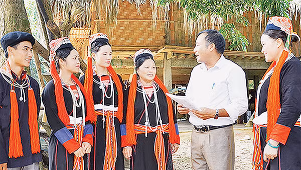 Tuyên truyền viên xã Chiêu Yên (huyện Yên Sơn, tỉnh Tuyên Quang) giải thích chính sách pháp luật cho bà con người dân tộc Dao thôn Tân Lập. Ảnh: TRANG TÂM