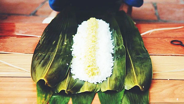 Gói bánh chưng bằng lá chít. Ảnh: SAOSTAR