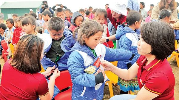 Cán bộ, đoàn viên thanh niên Công ty Du lịch Vietravel tặng áo ấm cho học sinh điểm Trường tiểu học Tọt Còn, xã Cao Thượng, huyện Ba Bể (Bắc Kạn).Ảnh: Nguyễn Ðăng