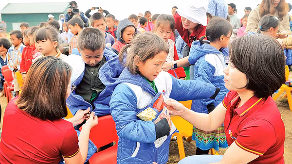 Cán bộ, đoàn viên thanh niên Công ty Du lịch Vietravel tặng áo ấm cho học sinh điểm Trường tiểu học Tọt Còn, xã Cao Thượng, huyện Ba Bể (Bắc Kạn).Ảnh: Nguyễn Ðăng