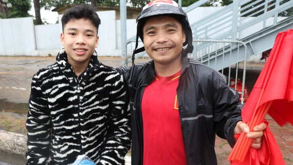 Hai cha con anh Nam bán cờ với hy vọng có thêm tiền để mua vé vào sân. (ẢNH: Sơn Bách)