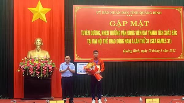 Phó Bí thư Thường trực Tỉnh ủy Quảng Bình Trần Hải Châu trao thường và tặng hoa cho Nguyễn Huy Hoàng.