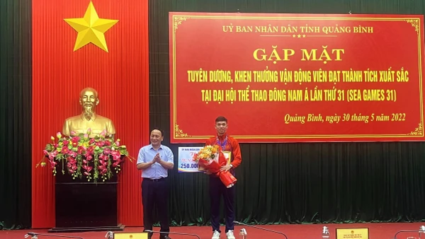 Phó Bí thư Thường trực Tỉnh ủy Quảng Bình Trần Hải Châu trao thường và tặng hoa cho Nguyễn Huy Hoàng.