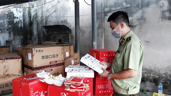 Cán bộ quản lý thị trường kiểm tra chất lượng sản phẩm bánh, kẹo nhập khẩu. (Ảnh: NGUYÊN TRANG)