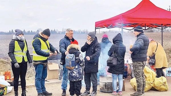 Một em bé sơ tán lạc mẹ đang được các tình nguyện viên Nga giúp.