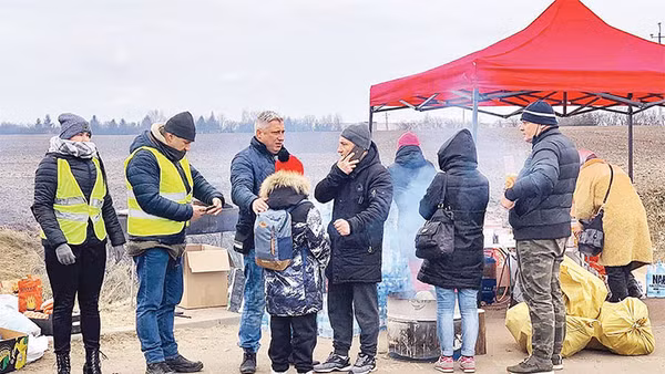 Một em bé sơ tán lạc mẹ đang được các tình nguyện viên Nga giúp.