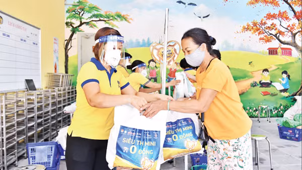 Nhân viên Công ty CP Vàng bạc đá quý Phú Nhuận (PNJ) hỗ trợ người dân tại “Siêu thị mini 0 đồng” trên địa bàn Hà Nội. Ảnh: Thủy Nguyên 