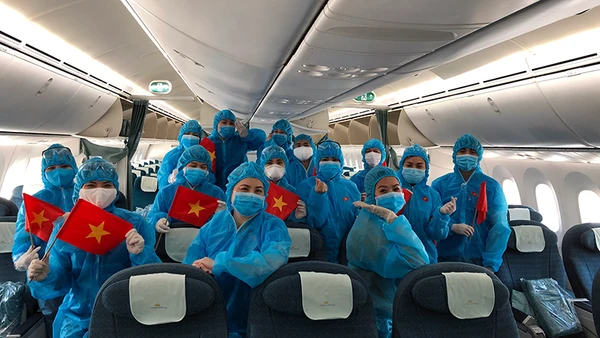 Tổ bay Vietnam Airlines trước khi khởi hành chuyến bay hồi hương cho công dân Anh từ Việt Nam và cho công dân Việt Nam từ Anh về nước. Nguồn: VNA