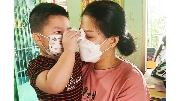 Em bé đang lau nước mắt cho mẹ. Sau mất mát, các con nhận về nhiều sự quan tâm, hỗ trợ từ cộng đồng.