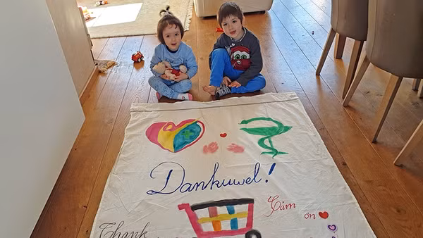 Các con của chị Thanh cùng mẹ làm băng-rôn bằng ba thứ tiếng Hà Lan - Việt Nam - Anh, cảm ơn những người đang ngày đêm nỗ lực cứu chữa bệnh nhân, phục vụ cộng đồng.