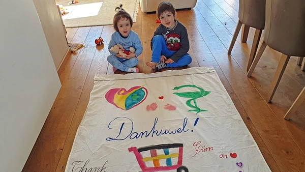 Các con của chị Thanh cùng mẹ làm băng-rôn bằng ba thứ tiếng Hà Lan - Việt Nam - Anh, cảm ơn những người đang ngày đêm nỗ lực cứu chữa bệnh nhân, phục vụ cộng đồng.