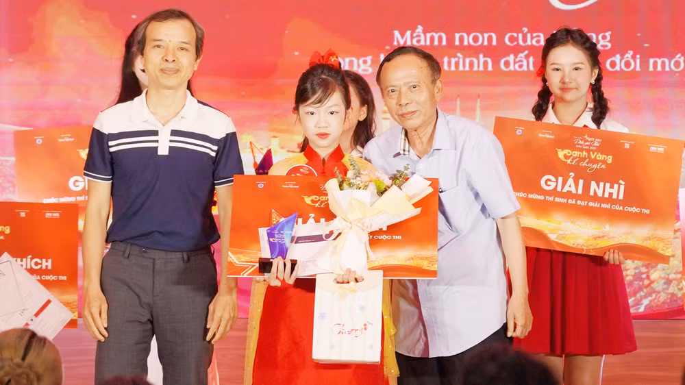 Nhà văn, nhà báo Hoàng Dự, Tổng Biên tập Thời báo Văn học Nghệ thuật, Trưởng Ban Tổ chức trao giải nhất cho Hoàng Ngọc Bảo Anh. (Ảnh: BTC)