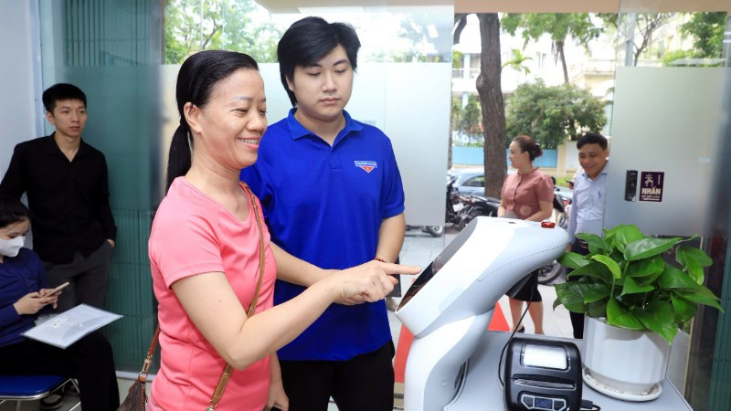 Người dân trên địa bàn phường Cửa Nam phấn khởi khi được robot hướng dẫn làm thủ tục hành chính.