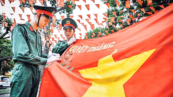 Các chiến sĩ tiêu binh danh dự cài huy chương trên Quân kỳ quyết thắng. (Ảnh: THÀNH ĐẠT)