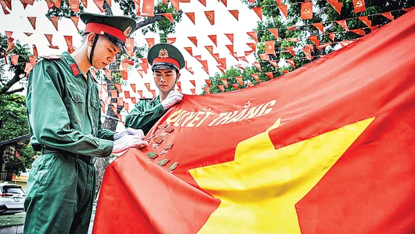 Các chiến sĩ tiêu binh danh dự cài huy chương trên Quân kỳ quyết thắng. (Ảnh: THÀNH ĐẠT)