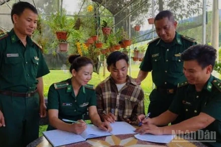 Cán bộ Bộ đội Biên phòng Sơn La hỗ trợ em Thào Tra Pó làm hồ sơ nhập học vào trường Đại học Tài nguyên và Môi trường.