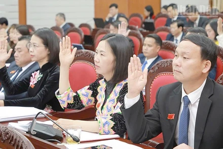 Các đại biểu biểu quyết thông qua các nghị quyết tại kỳ họp thứ 12, Hội đồng nhân dân tỉnh Sơn La khóa XV.