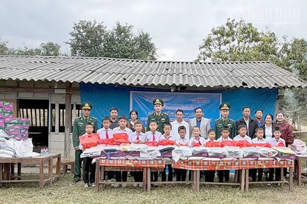 Cán bộ, chiến sĩ Đồn Biên phòng Cửa khẩu Chiềng Khương phối hợp đoàn thiện nguyện trao tặng quà cho học sinh trường tiểu học Huoicu, huyện MuongEt, tỉnh Huaphanh, nước bạn Lào.
