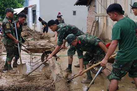 Cán bộ, chiến sĩ Bộ Chỉ huy Quân sự tỉnh Sơn La giúp người dân các bản xã Chiềng Sơ, Mường Lầm khắc phục hậu quả mưa lũ.