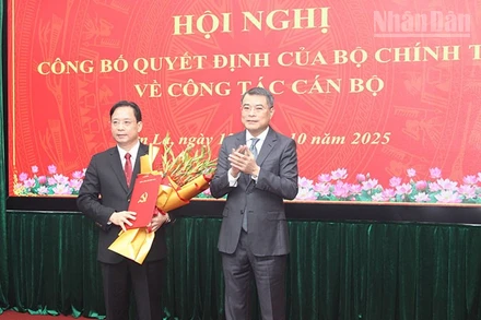 Đồng chí Lê Minh Hưng, Ủy viên Bộ Chính trị, Bí thư Trung ương Đảng, Trưởng ban Tổ chức Trung ương trao quyết định của Bộ Chính trị và tặng hoa chúc mừng đồng chí Hoàng Văn Nghiệm.