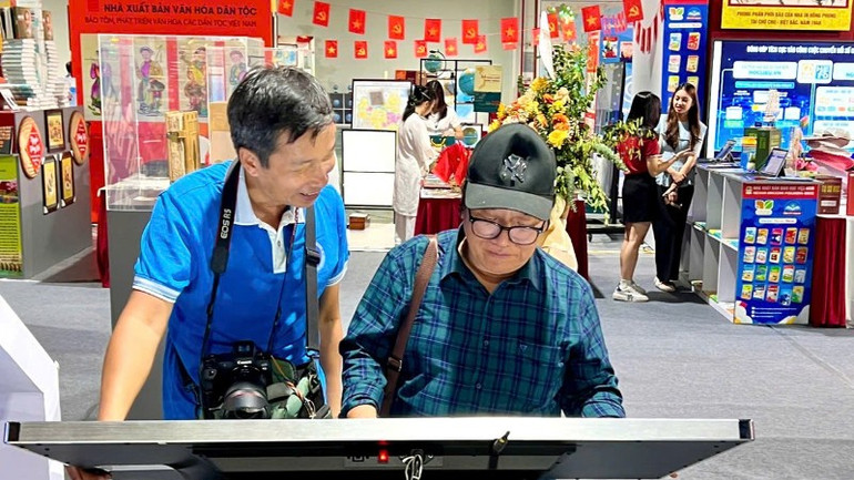 詩人のトラン・ダン・コア氏(右)とエンジニア兼写真家のトラン・タン氏が電子書籍を体験。 z6956989303684-ead5cea8aeecb7f6b2be70cd251b1ea2-8101.jpg